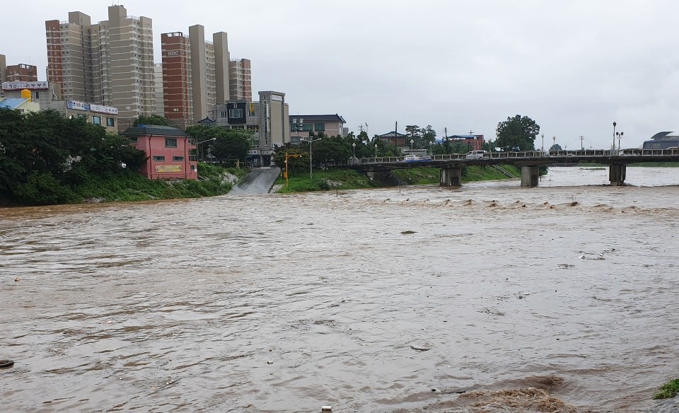 시간당 30mm안팎의 거센 폭우가 쏟아지자, 포천시 포천천 민속5일장 하천 다리가 물에 잠겼다. 포천천 물이 불어나자, 하천변 공영주차장과 산책로 출입이 통제되고 있다.